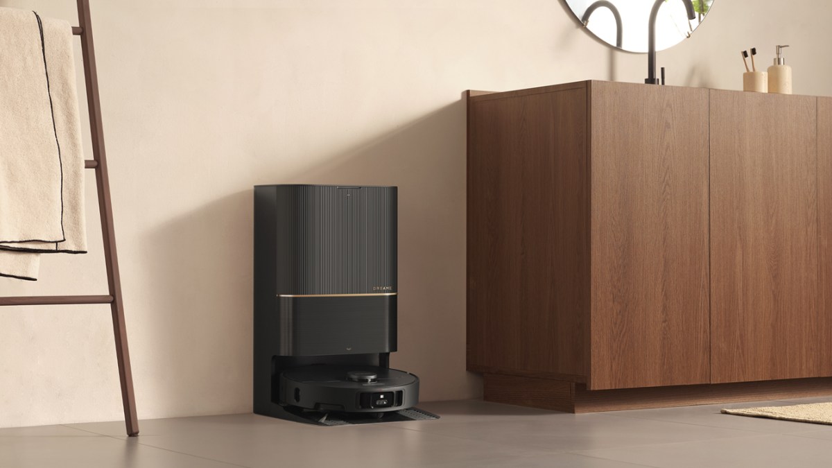 A robot vacuum cleaner next to a cabinet
